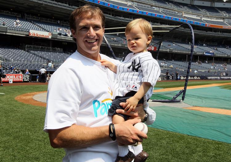 Drew Brees stands on the field with his son Baylen, his first son. Brees and his wife will have their second son soon. (Jim McIsaac/Getty Images)