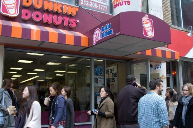 Patrons emerge from a Dunkin' Donuts in New York City with free ice teas and ice coffees. (Jack Phillips/The Epoch Times)