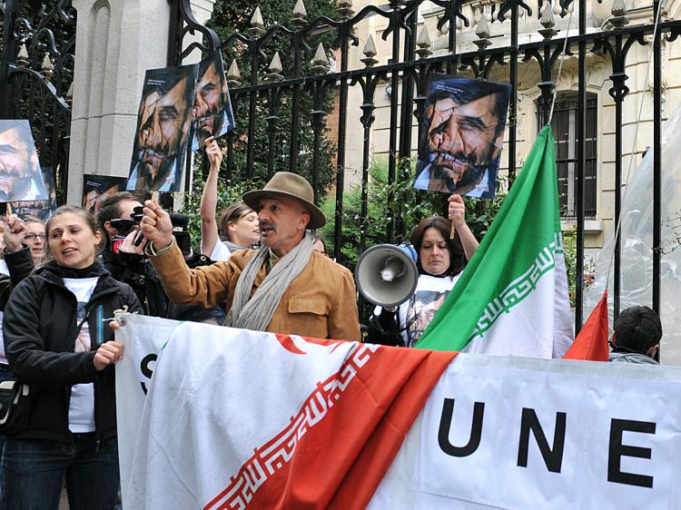 Iranian photographer Reza (C with hat) and media rights watchdog Reporters Without Borders (RSF) members hold up crumpled portraits of Iranian President Mahmoud Ahmadinejad during a protest in front of the Iranian embassy in Paris, on May 3, 2010, calling for the release of journalists imprisoned in Iran. (Miguel Medina/AFP/Getty Images)