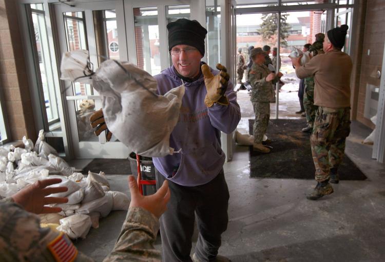 National Guardsmen and volunteers sandbag the gymnasium on the campus of the Oak Grove Lutheran School following a break in the levee on the campus March 29 in Fargo, North Dakota. (Scott Olson/Getty Images)