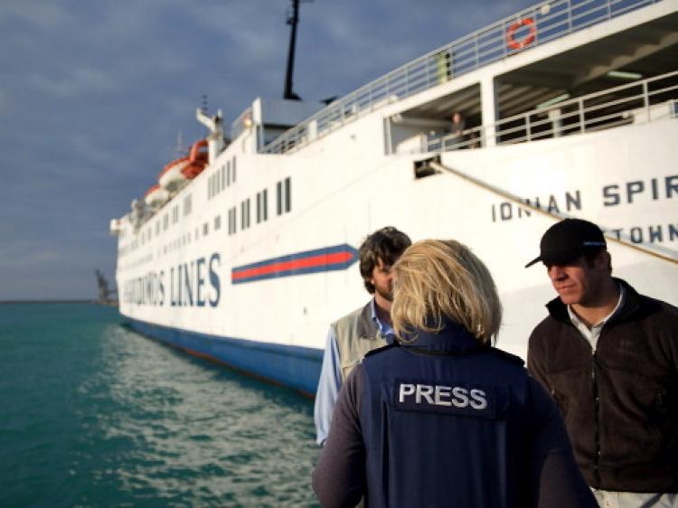 A member of the press with two men near a Greek ferry chartered by the International Organisation for Migration to rescue stranded foreign workers from the besieged Libyan city of Misrata. (Phil Moore/AFP/Getty Images)