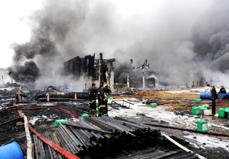 Firefighters extinguish a fire after battling flames which burned for 15 hours at a port in Dalian, northeast China's Liaoning province, on July 17, 2010.  (STR/AFP/Getty Images)