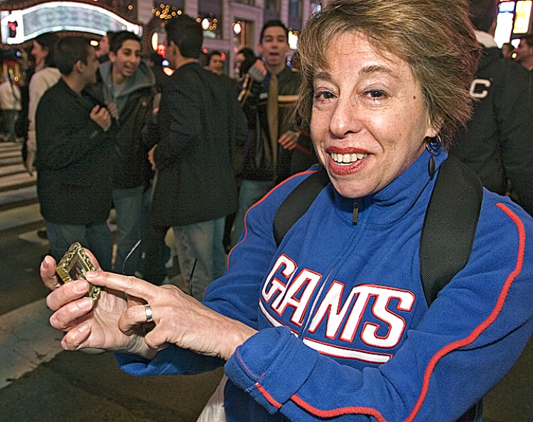 Giants super-fan Joanne Flaster holds a photo of her father in Times Square as she watched her team triumph over the Patriots in Super Bowl XLII. (Dayin Chen/The Epoch Times)
