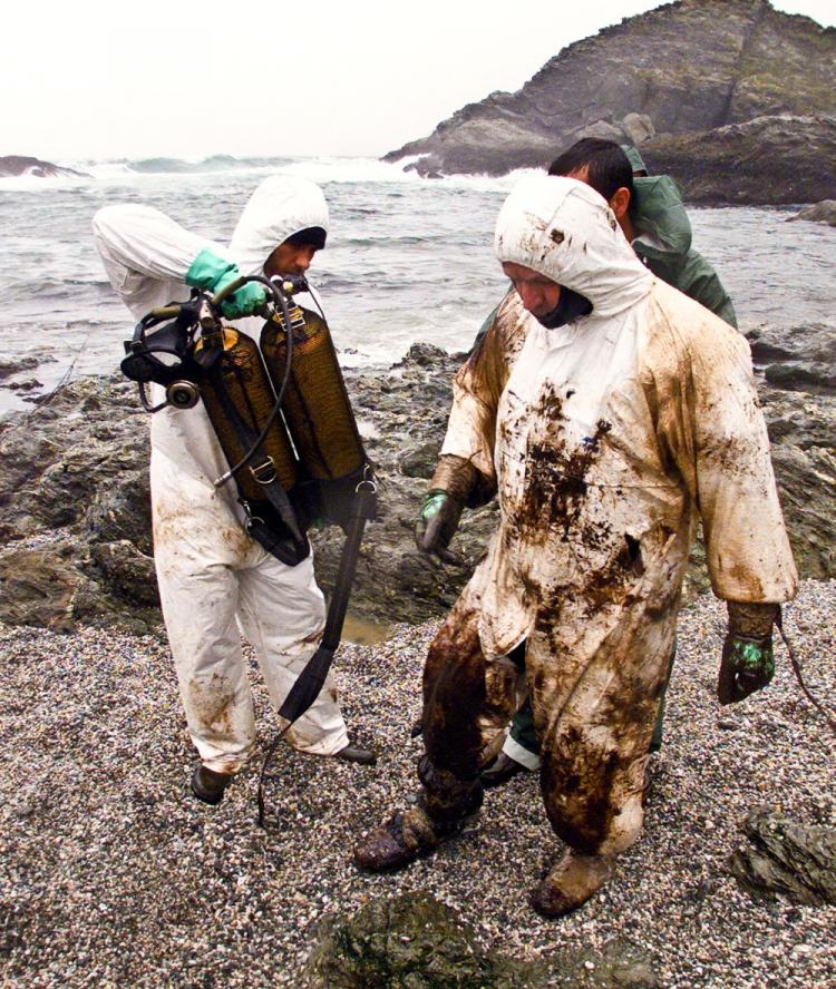 Picture taken Oct. 18, 2000, of divers in the rocks of Port-Blanc in Belle-Ile, western France, where they prepare to collect underwater oil residues from the Erika oil spill. (Marcel Mochet/AFP/Getty Images )