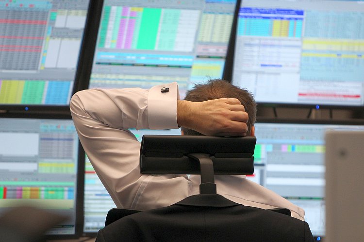 A broker sits in front of screens showing the German market rates
