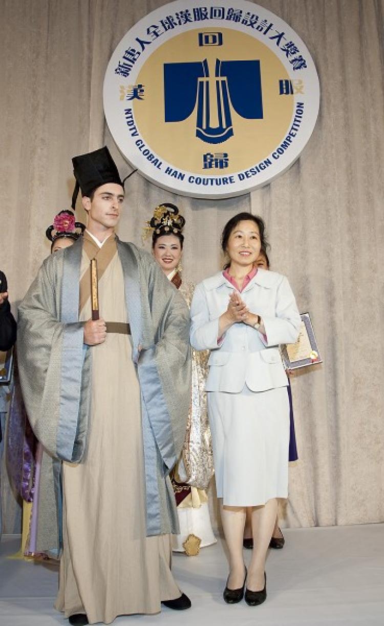 Designer Cheng Minghua (R) stands with his model in the winning piece of the competition. The outfit is in the style of the Ming Dynasty.  (Edward Dai/The Epoch Times)