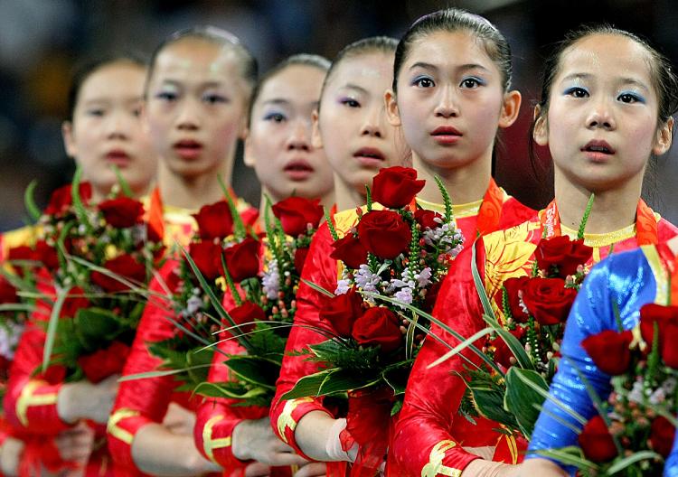 The girls of the gold-medal-winning Chinese women's gymnastics team might have seen their parents once a year since age three, when the state put the girls in a training program. (Al Bello/Getty Images)