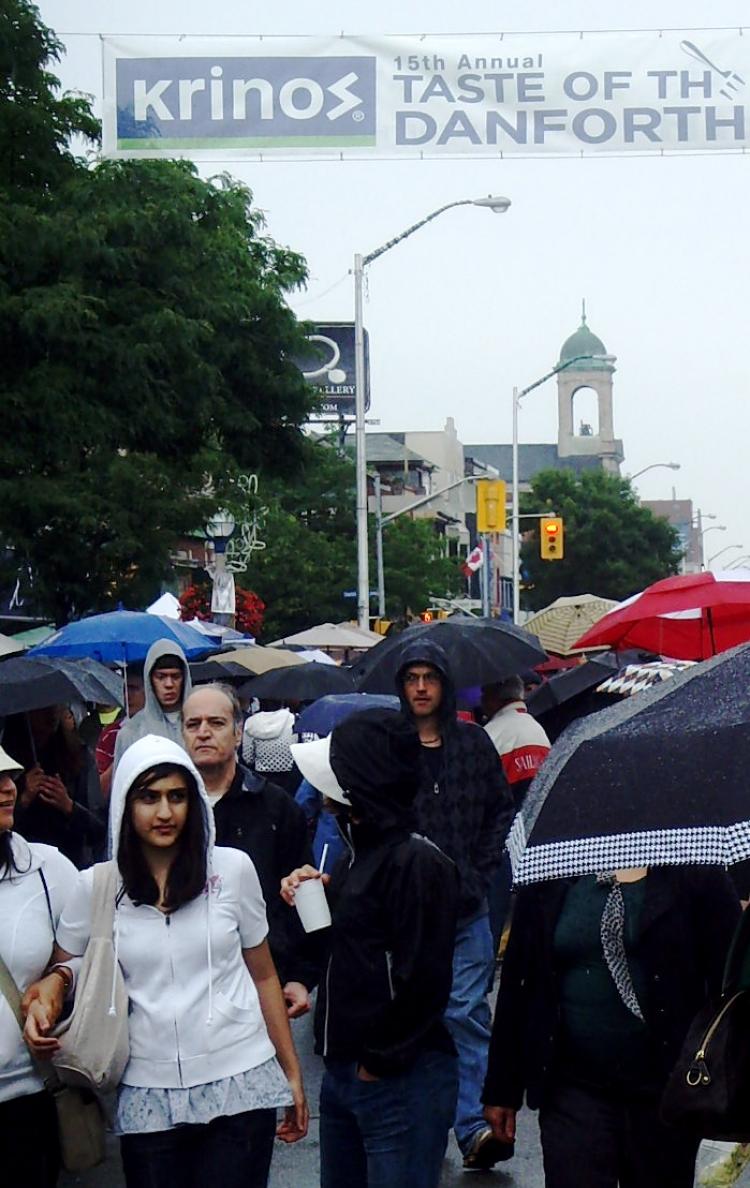 Taste of Danforth revellers sample Greek food and music under a canopy of umbrellas. (Debora de Souza/The Epoch Times)