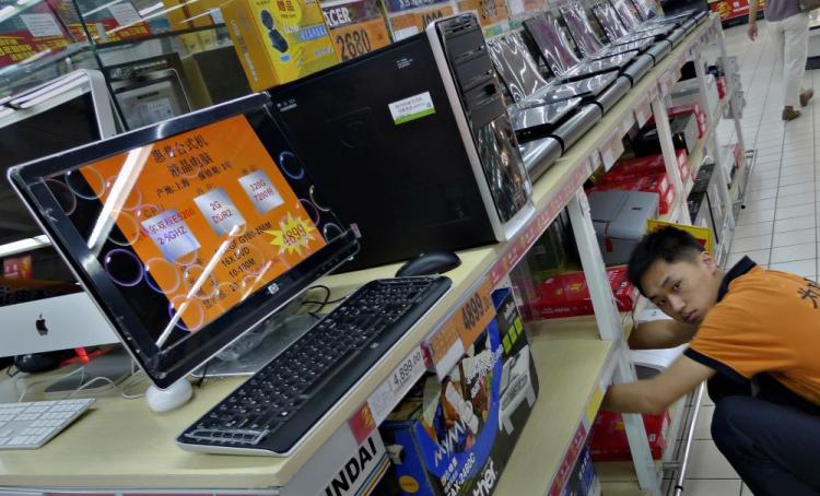 A salesman adjusts computer items at a supermarket in Beijing. The Chinese regime's Green Dam-Youth Escort filtering software has become a censorship boondoggle. (Liu Jin/AFP/Getty Images)