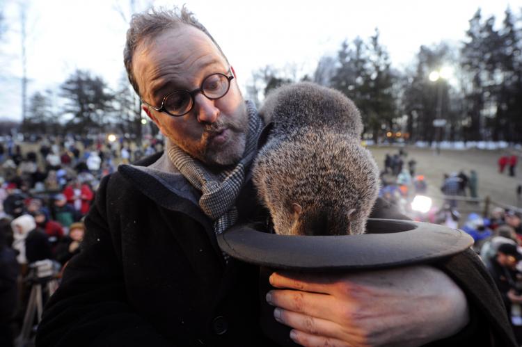 Groundhog handler Ben Hughes watches Punxsutawney Phil after he emerged from his burrow and failed to see his shadow, thus predicting an early spring during the 125th annual Groundhog Day festivities on Feb. 2 in Punxsutawney, Pa. (Jeff Swensen/Getty Images)