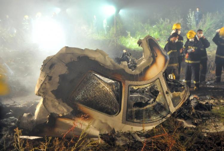 Chinese firefighters search the cockpit of the Henan Airlines ERJ-190 jet wreckage at the crashsite in the northeast city of Yichun in remote Heilongjiang province early on August 25, 2010. A large number of Chinese pilots falsify their flight credentials in order to land better jobs. (STR/AFP/Getty Images)