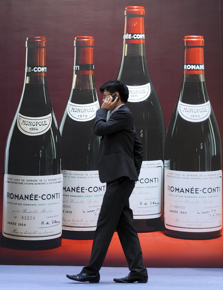 A man walks past a poster advertising fine wines