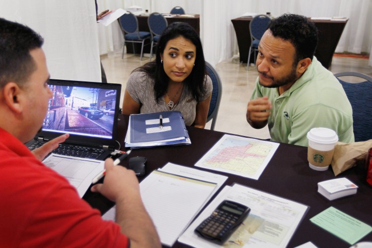 Michelle Ruiz (L) and Nilson Ruiz listen as Wells Fargo home mortgage consultant, Michael Carreras, helps the potential homeowners with their application for a down payment assistant grant at the Miami Airport Convention Center on June 1, in Miami, Fla. The American dream of owning a home is still going strong with a recent survey with 57 Percent of respondents saying owning a home is among the best long-term investments they could make. (Joe Raedle/Getty Images)