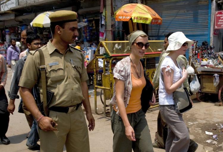 Foreign tourists are watched by an Indian policeman as they walk along a street in New Delhi on May 2. Thousands of Indian police and paramilitary troops are guarding New Delhi's markets and shopping centers after a series of warnings from foreign embassies of an imminent militant attack. (Manpreet Romana/AFP/Getty Images)
