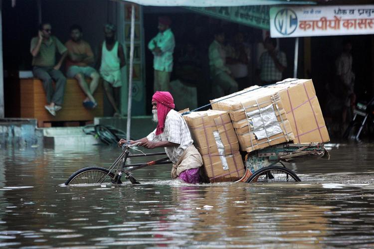 Indian commuters make their way through a waterlogged street after a heavy downpour flooded parts of Amritsar on August 13, 2008.  (Narinder Nanu/AFP/Getty Images)