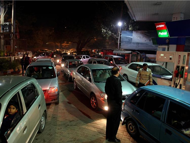 Indian commuters rush to a crowded petrol station in New Delhi on January 8, 2009.   (Manan Vatsyayana/AFP/Getty Images)