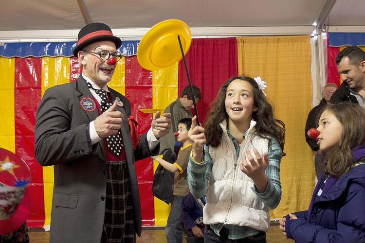 KIDS WEEK: Children take a turn at plate spinning with the help of a Barnum and Bailey Circus clown during Kids Week festivities on the USS Intrepid on Sunday.  (Phoebe Zheng/The Epoch Times)