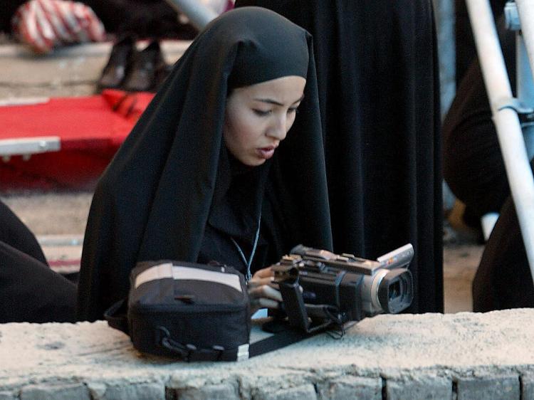 In a picture dated June 3, 2004, U.S.-Iranian journalist Roxana Saberi takes footage during a ceremony marking the 15th anniversary of the death of supreme leader Ayatollah Ruhollah Khomeini at Khomeini's mausoleum in the southern outskirts of Tehran.    (Behrouz Mehri/AFP/Getty Images)