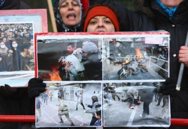 Women hold photographs showing scenes from recent violent, anti-government demonstrations in Tehran while protesting outside the Iranian embassy on December 28, 2009 in Berlin, Germany. (Sean Gallup/Getty Images)