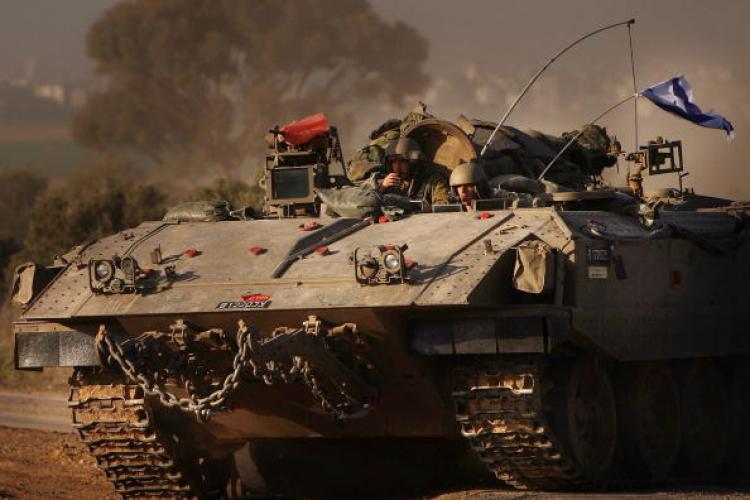 Israeli soldiers ride in a armored personnel carrier (APC) along the Israeli, Gaza border in Israel.  (Spencer Platt/Getty Image)