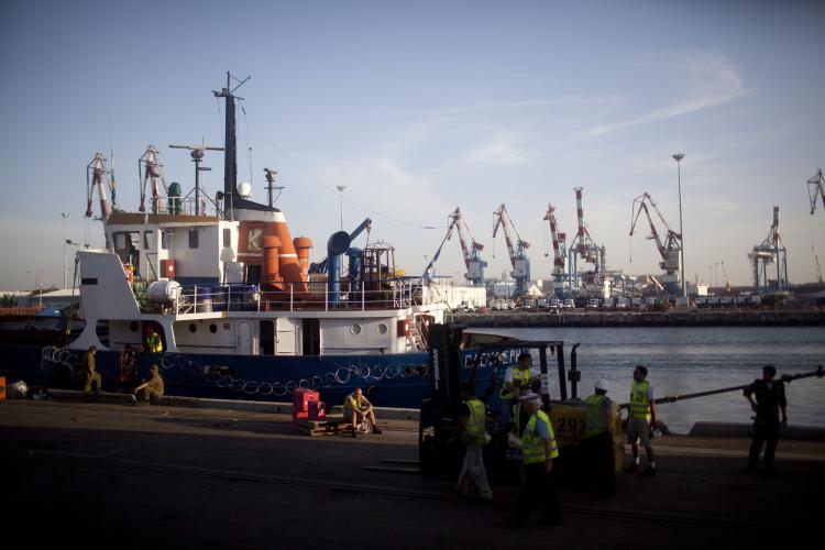 Israeli port workers unload humanitarian Aid from one of the Peace Gaza Flotilla ships at the Ashdod Port on June 1. The Israeli government said on Tuesday that it will release all detained flotilla passengers.  (Uriel Sinai/Getty Images)