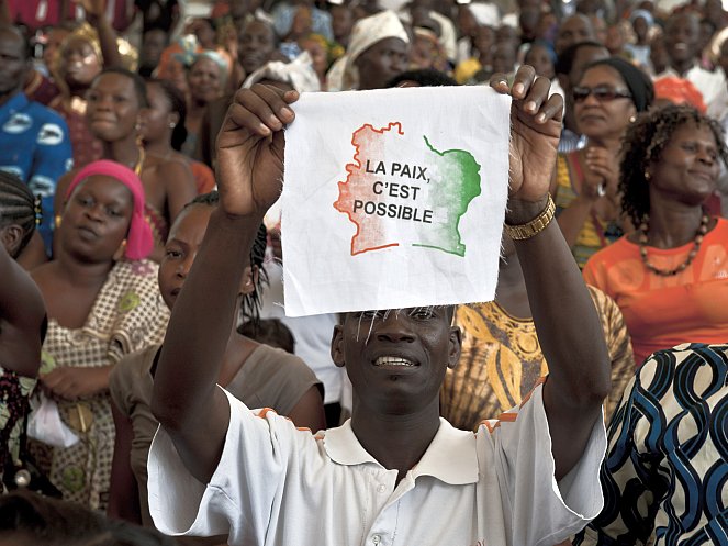  An Ivorian man displays a message on a piece of fabric reading in French 