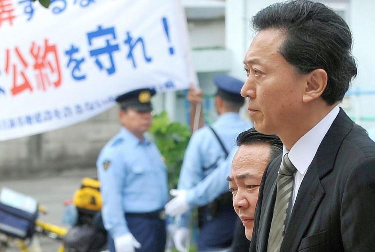 Japanese Prime Minister Yukio Hatoyama walks past a banner which reads 'Keep the pledge!' in Naha, Okinawa Prefecture, after his meeting with Okinawa Governor Hirokazu Nakaima and 12 mayors on May 23. Hatoyama apologized for breaking his election pledge to move an unpopular US military base off Okinawa. (Jiji Press/AFP/Getty Images)