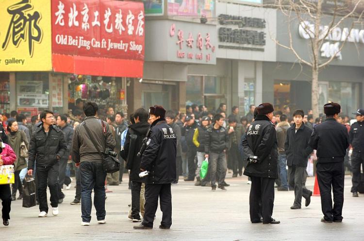 Police keep watch along the Wanfujing shopping street in Beijing after protesters gathered on February 20, 2011. Postings circulating on the Internet called on disgruntled Chinese to gather in public places in 13 major cities to mark the 'Jasmine Revolution' spreading through the Middle East. (Peter Parks/AFP/Getty Images)