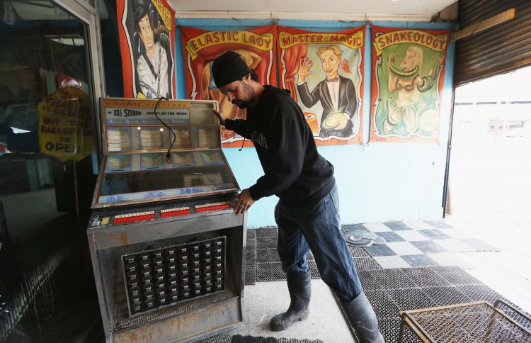 Patrick Wall, house manager at Coney Island USA, moves a jukebox damaged in the flooding of the buildings that house the Coney Island Circus Sideshow and the Coney Island Museum, Nov. 15. Many businesses and nonprofits remain closed in the area, but some have been opening without power. (Mario Tama/Getty Images)