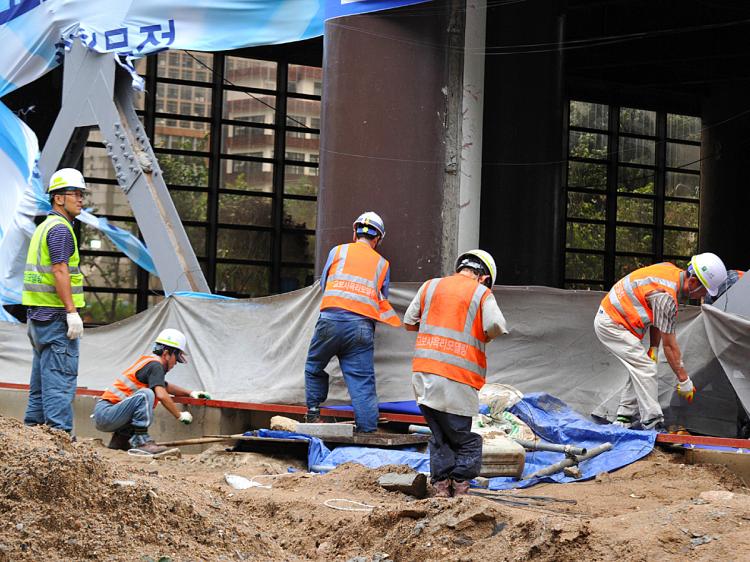 South Korean workers clean up damage done by Typhoon Kompasu. The typhoon killed dozens in North Korea. (Kim Jae-Hwan/AFP/Getty Images)