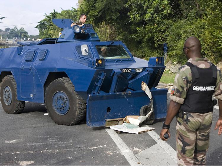 French gendarme watches as barricades set up by activists of the Collective against Exploitation (LKP) are removed, on February 16, 2009 in Gosier, Caribbean islands of Guadeloupe.  (Julien Tack/AFP/Getty Images)