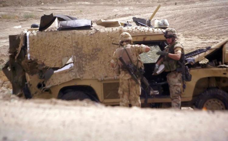 British soldiers inspect a 'Snatch Land Rover' Sept. 4, 2006, in the city of Basra, Iraq. At least 36 British soldiers have been killed in roadside bombs while being transported in Snatch Land Rovers. Amid mounting accusations that the vehicles are putting soldiers' lives at risk, the U.K. government has announced that it will withdraw the vehicles from Afghanistan. (Essam Al-Sudani/AFP/Getty Images)