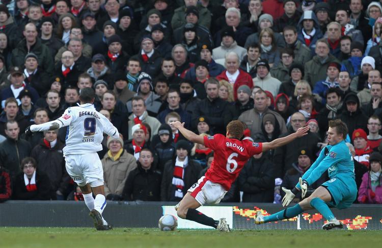 Jermaine Beckford (left) scores despite the efforts of Wes Brown (center) and Tomasz Kuszczak. (Alex Livesey/Getty Images)