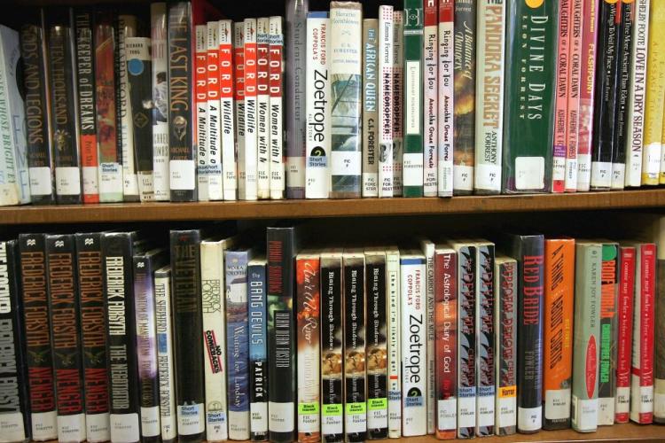 Books sit on a shelf at the Brooklyn Public Library. 'Huck Finn' is widely considered to be a great American novel. Huck is immersed in his racist time of the 1840s, breathing in and exhaling its vile language as we breathe air. (Spencer Platt/Getty Images)