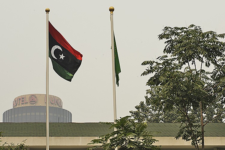 The flag (L) of the Libyan transitional government flies at the Libyan Embassy in Beijing on August 23. In past months, the Chinese regime has taken contradictory stances toward the rebel's efforts to overthrow the Libyan tyranny. (Peter Parks/AFP/Getty Images)