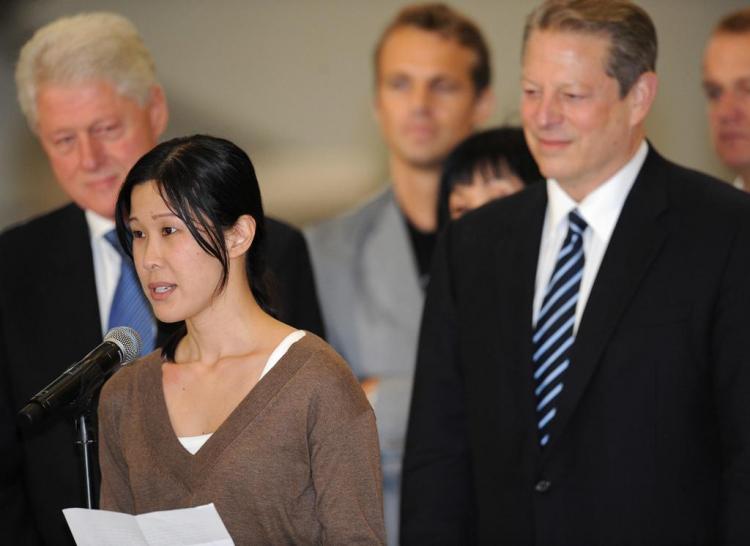 Former US president Bill Clinton (L) and US vice president Al Gore (R) look on as freed US journalist Laura Ling reads a statement at the airport in Burbank, California on August 5, 2009. Following talks in Pyongyang with Clinton, North Korean leader Kim Jong Il pardoned Lee and Ling who were sentenced to hard labor for entering the country illegally. (Robyn Beck/AFP/Getty Images)