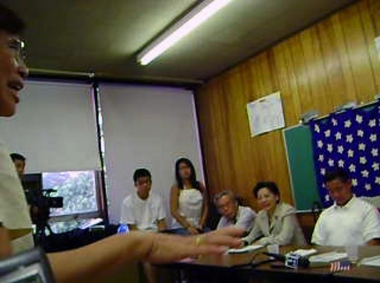 New York Councilman John Liu (right) plays with his cell phone while Taiwanese American Mr. Wang Suhua speaks at the August 18 meeting. (The Epoch Times)