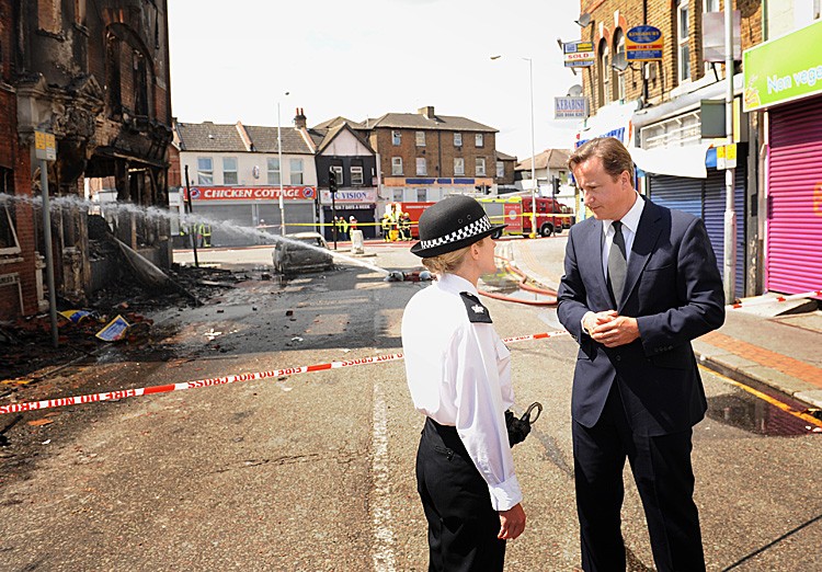 Prime Minister David Cameron talks to Acting Borough Commander Superintendent Jo Oakley during a visit to Croydon, South London on August 9. In the first known riot-related fatality, a 26-year-old man died in hospital after being found with gunshot wounds (Stefan Rousseau-WPA Pool/Getty Images)
