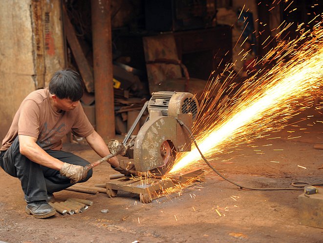 A machinist uses an industrial saw to cut a steel bar at a workshop IN Shanghai on Aug. 23. A recent paper by the Economic Policy Institute pins a lot of the blame for U.S. unemployment on the U.S. trade deficit with the Chinese state. (PETER PARKS/AFP/GettyImages) 