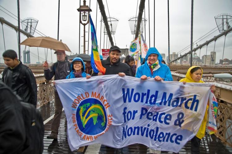 Peace activists march across the Brooklyn Bridge on Monday despite the rainy weather. (Aloysio Santos/The Epoch Times)