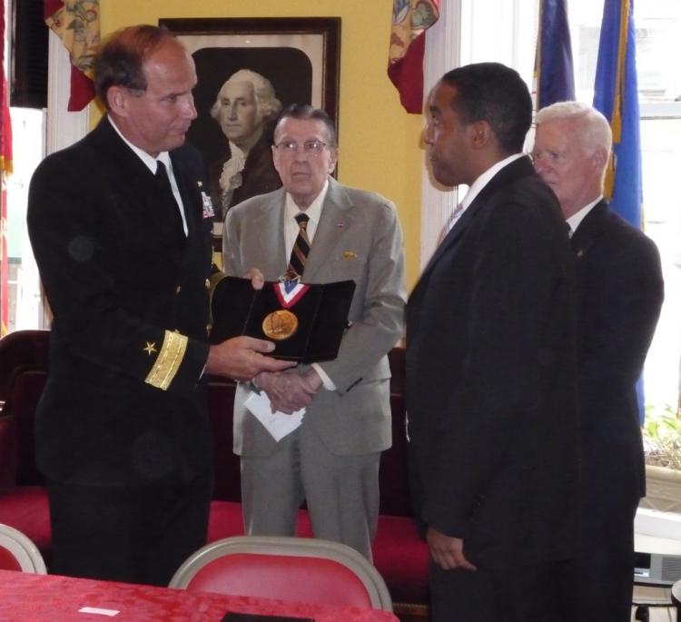 HONORED: Scott Wright of the Marine Corps receives a medal from Navy Rear Admiral Mark Kenny to welcome him into the Soldiers', Sailors' Marines', Coast Guard and Airmen's Club's Board of Honor.  (Christine Lin/The Epoch Times)