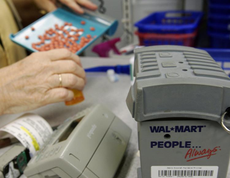 Medicaid budget gaps will force restrictions and cuts on services and coverage, a report on Thursday said. Pictured above, a Wal-Mart pharmacist fills prescription drug orders at a store in Florida. (Robert Sullivan/AFP/Getty Images)