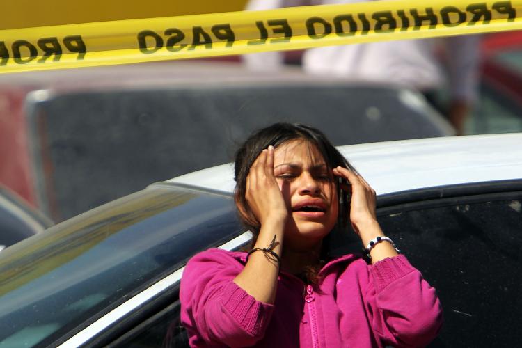 Family members grieve in front of a car in which two men 18 and 34, lay dead on March 22, in Juarez, Mexico. They were shot by a group of teenagers. A slew of drug-related violence is threatening to disrupt upcoming national elections in Mexico. (Spencer Platt/Getty Images)