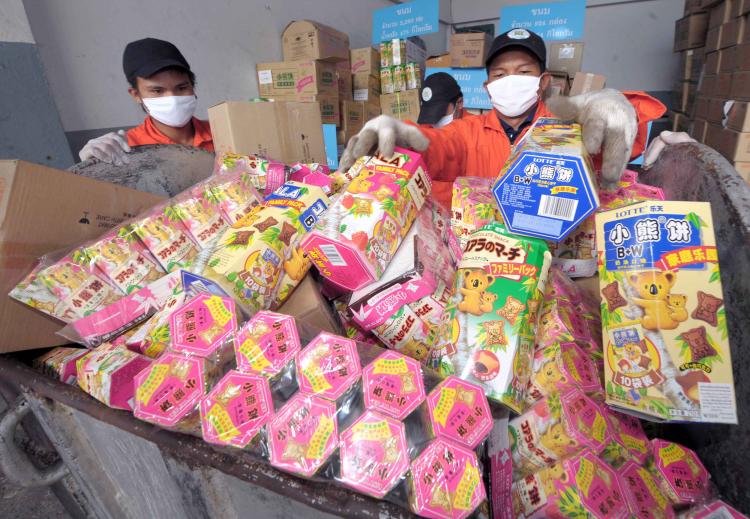GOT MELAMINE? Thai officials fill snacks and food products tainted with the toxic chemical melamine in a container prior to destruction in Ayutthaya, the capital city of Ayutthaya province on Nov. 10. (Pornchai Kittiwongsakula/AFP/Getty Images)