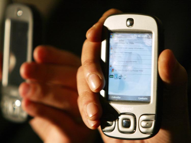 An Indian model displays a Dopod International windows compatable mobile phone/ PDA during a launch function in Mumbai, 05 Feburary 2007. (Sajjad Hussain/AFP/Getty Images)