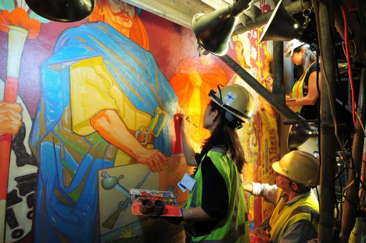 Conservators work on the left panel of one of the murals. (AMNH/D. Finnin)