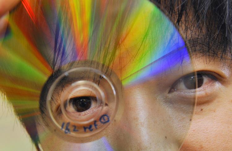 James Chon of Melbourne's Swinburne University of Technology holds up a DVD that can store data in five dimensions, making it possible to pack more than 2,000 movies onto a single disc. (William West/AFP/Getty Images)