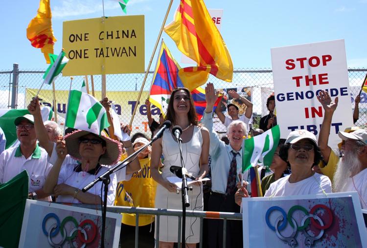 Human rights activist Nazanin Afshin-Jam asks rally attendees to wave at a Chinese embassy official who was filming the event from the embassy window.  (Samira Bouaou/The Epoch Times)