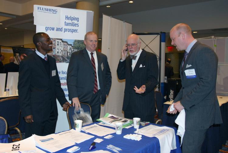 NETWORKING: Flushing Bank representatives discuss mortgages, purchasing, and refinancing of properties. Bankers rubbed shoulders with brokers at the NYC Real Estate Expo (Tara MacIsaac/The Epoch Times)