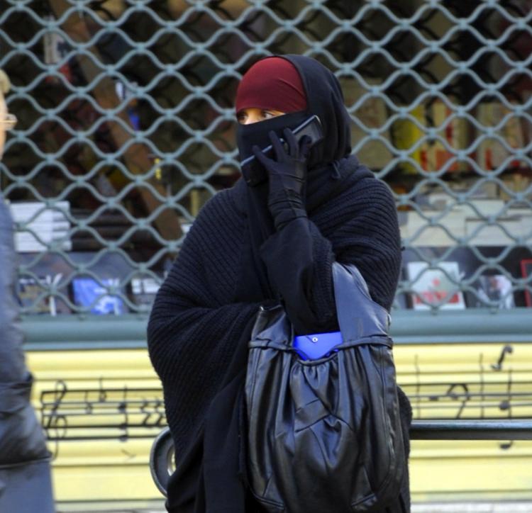 A woman wearing a niqab, the Islamic full veil, gives a phone call in a street of Lyon, Eastern France. (Philippe Desmazes/AFP/Getty Images)